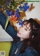 A woman holding a bunch of flowers in her hand.