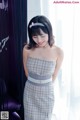 A woman in a plaid dress posing for a picture.