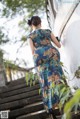 A woman in a blue dress is standing on some steps.