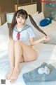 A woman in a sailor outfit sitting on a bed.