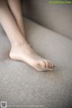 A close up of a woman's bare feet on a couch.