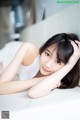 A woman laying on top of a white couch.