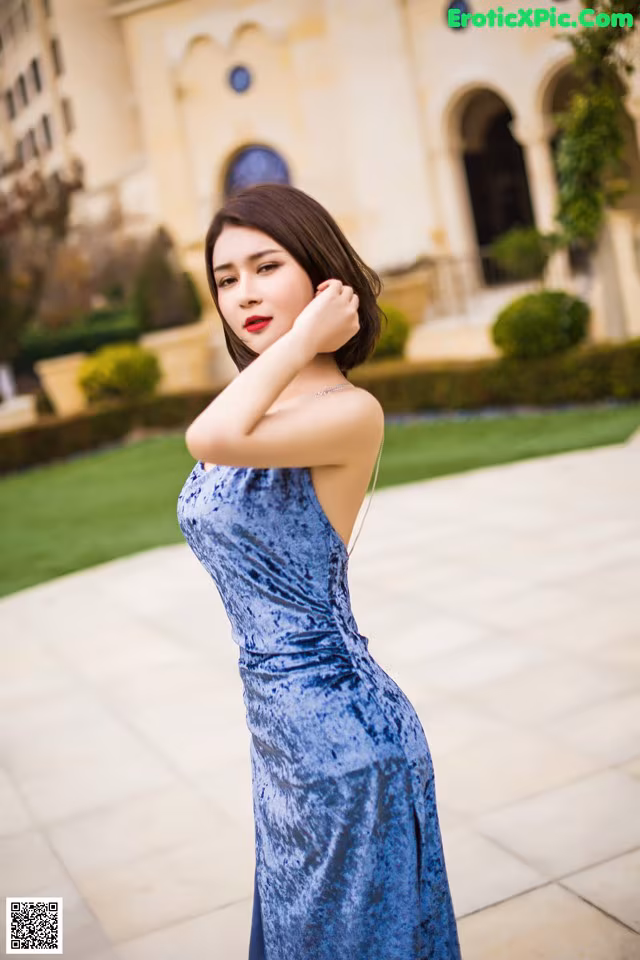 A woman in a blue dress posing for a picture.
