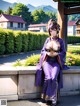 A woman in a purple kimono sitting on a wall.